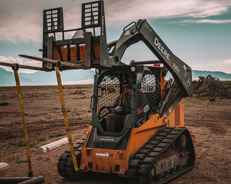 Operator in a John Deere track loader with a pier drive attachment