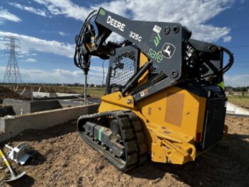 John Deere track loader with a drive head beside a new foundation