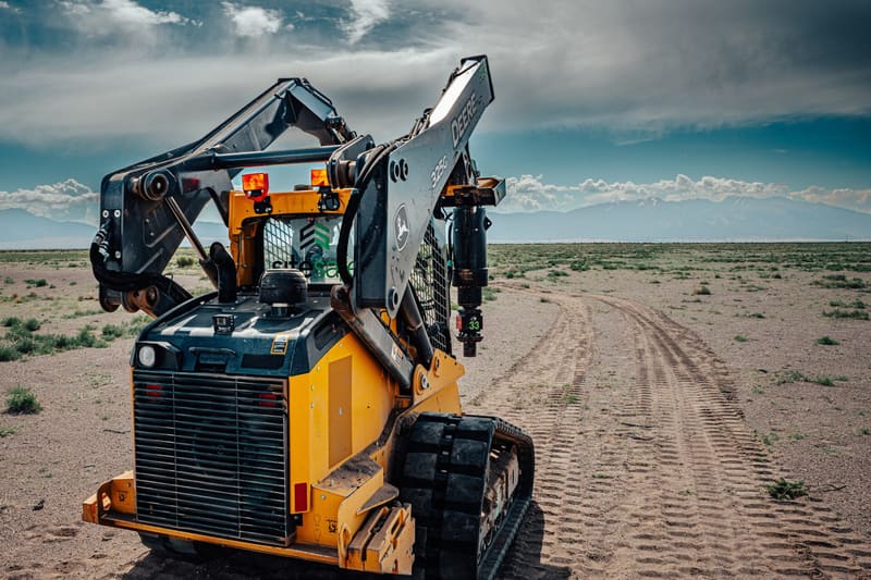 Track loader with a hydraulic drive head installing a helical pier