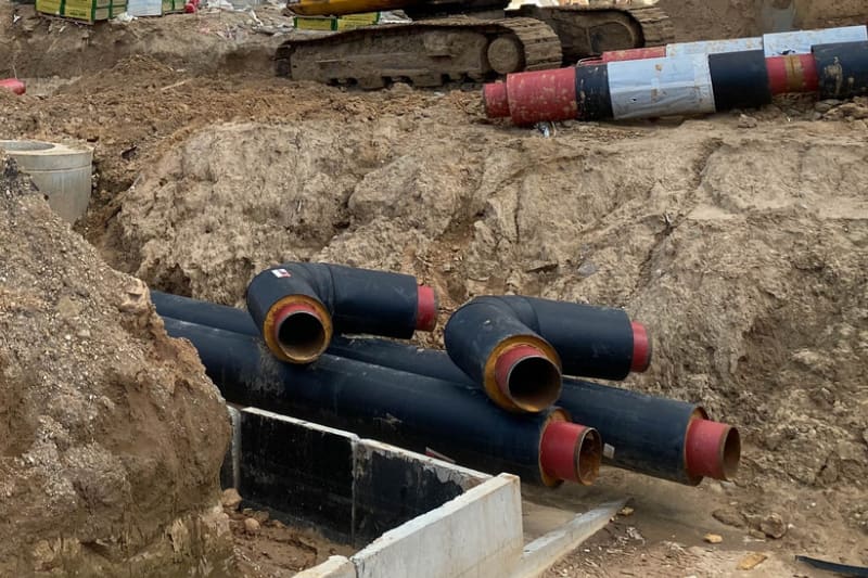 Insulated pipeline sections beside an excavation