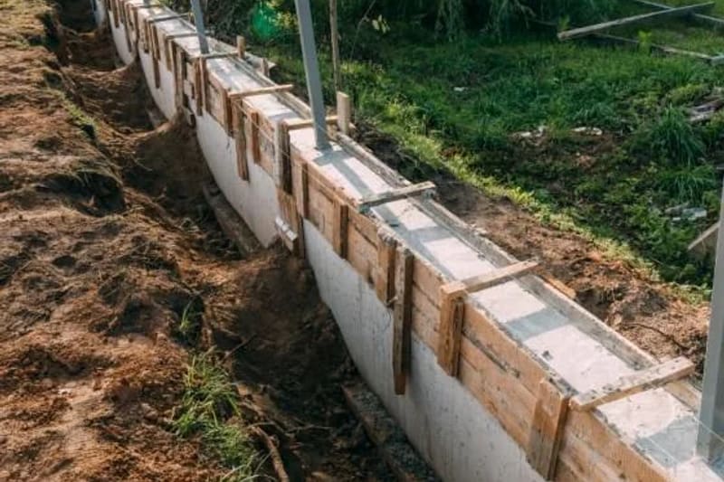 Retaining wall formwork on a helical pier foundation