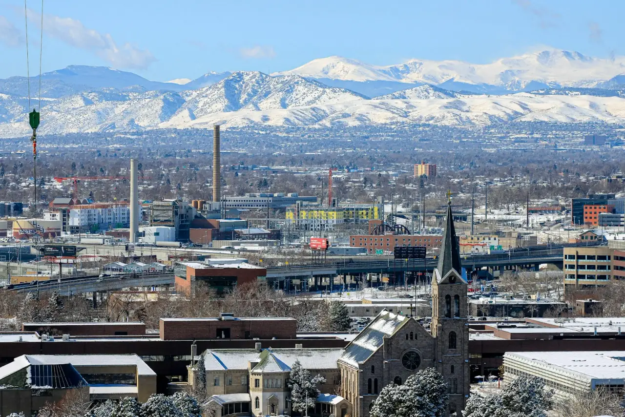 Snow-covered Front Range mountains behind a Colorado city in winter, where the frost line sets footing depth