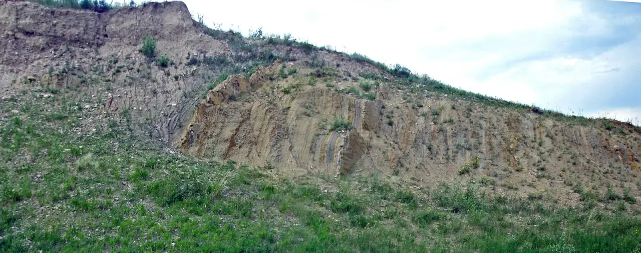 Hillside outcrop of steeply tilted gray-brown Pierre Shale beds on the east side of the Dakota Hogback west of Denver