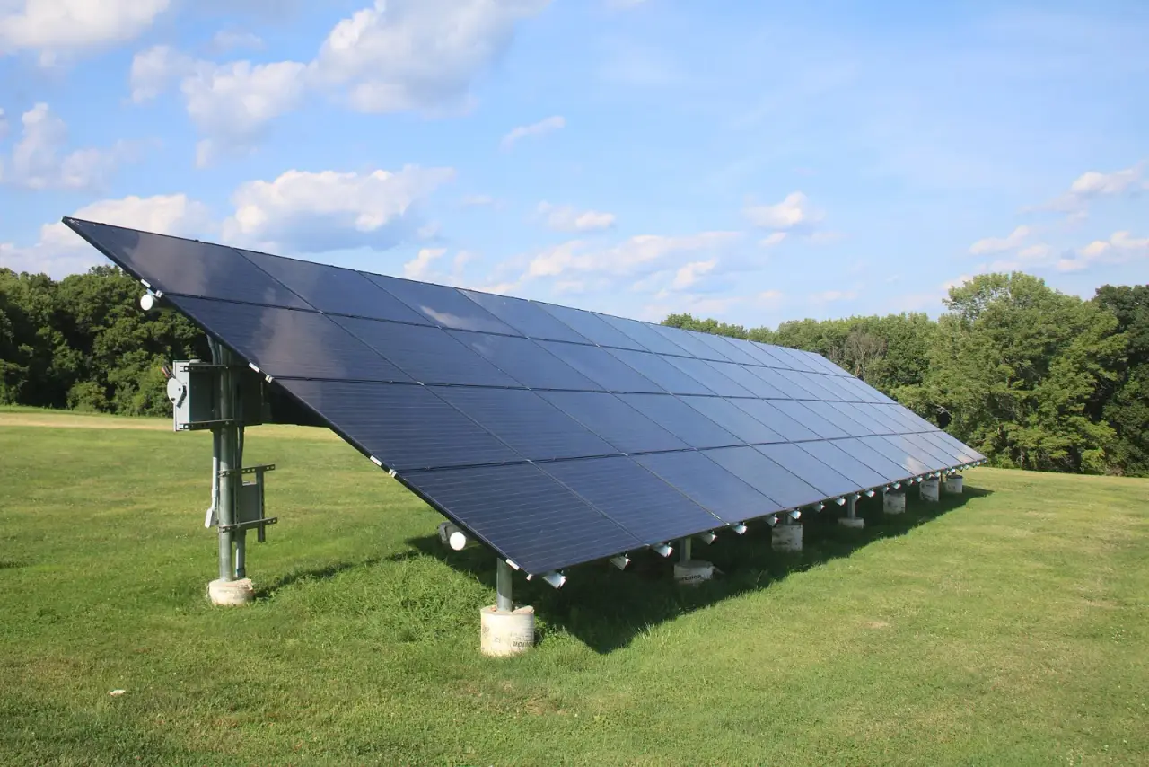 Residential solar ground mount installation with steel posts set in round concrete piers on a grassy lot